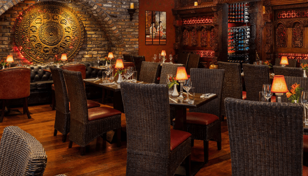 Interior of a cozy restaurant with candlelit wooden tables and warm atmosphere