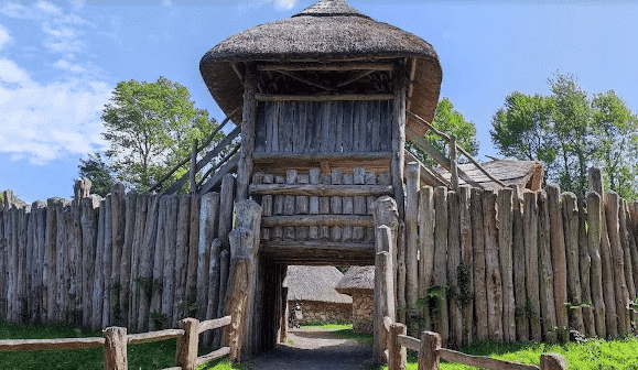 Massive timber-framed gatehouse entrance to a historic park or attraction