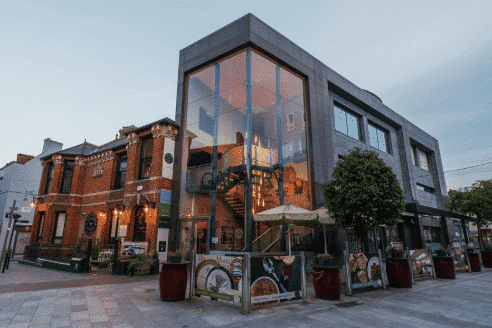 Contemporary urban building with large glass windows and red brick accents